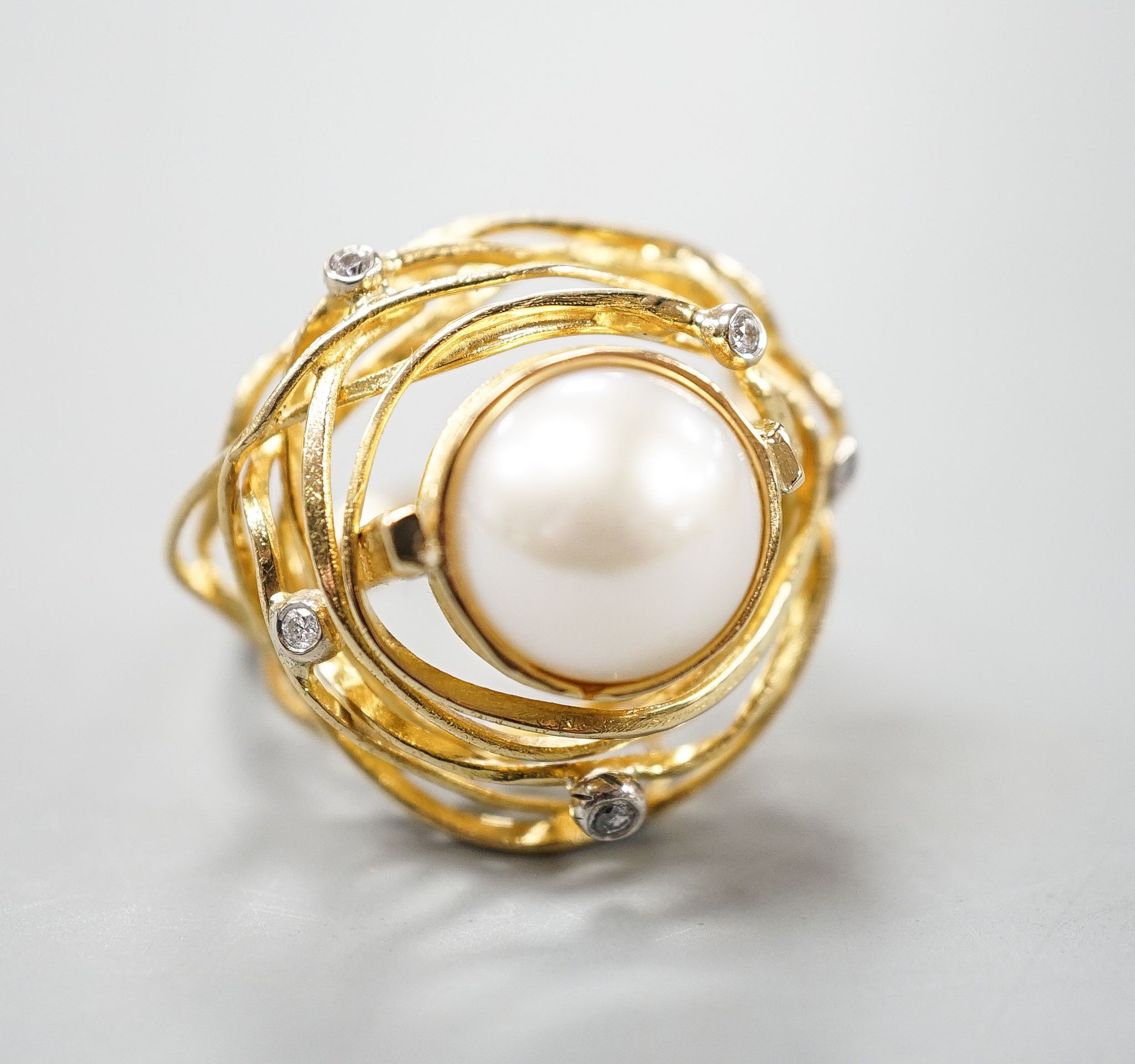 A modern 750 yellow metal, mabe pearl and diamond chip set modernist dress ring, size Q, gross 13.2 grams.